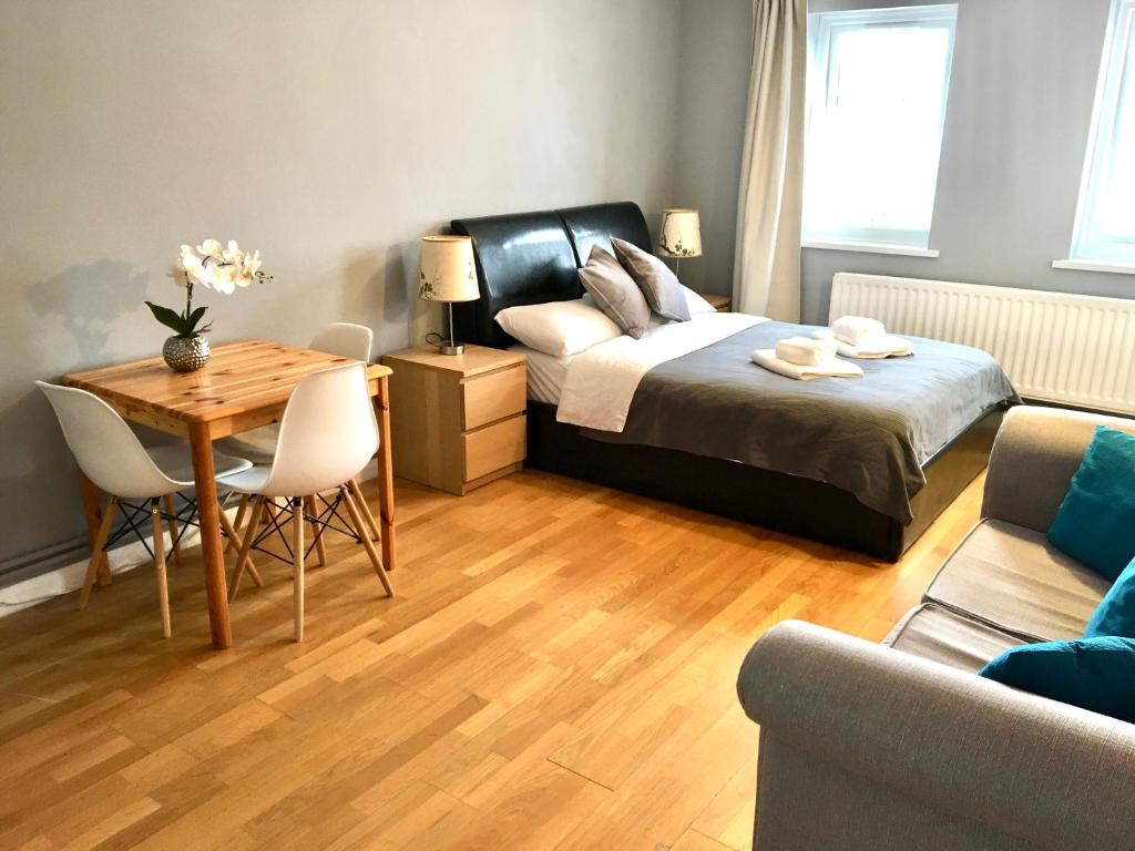 - une chambre avec un lit, une table et un canapé dans l'établissement Lovely Studio Room in the heart of Kingston upon Thames, à Kingston upon Thames