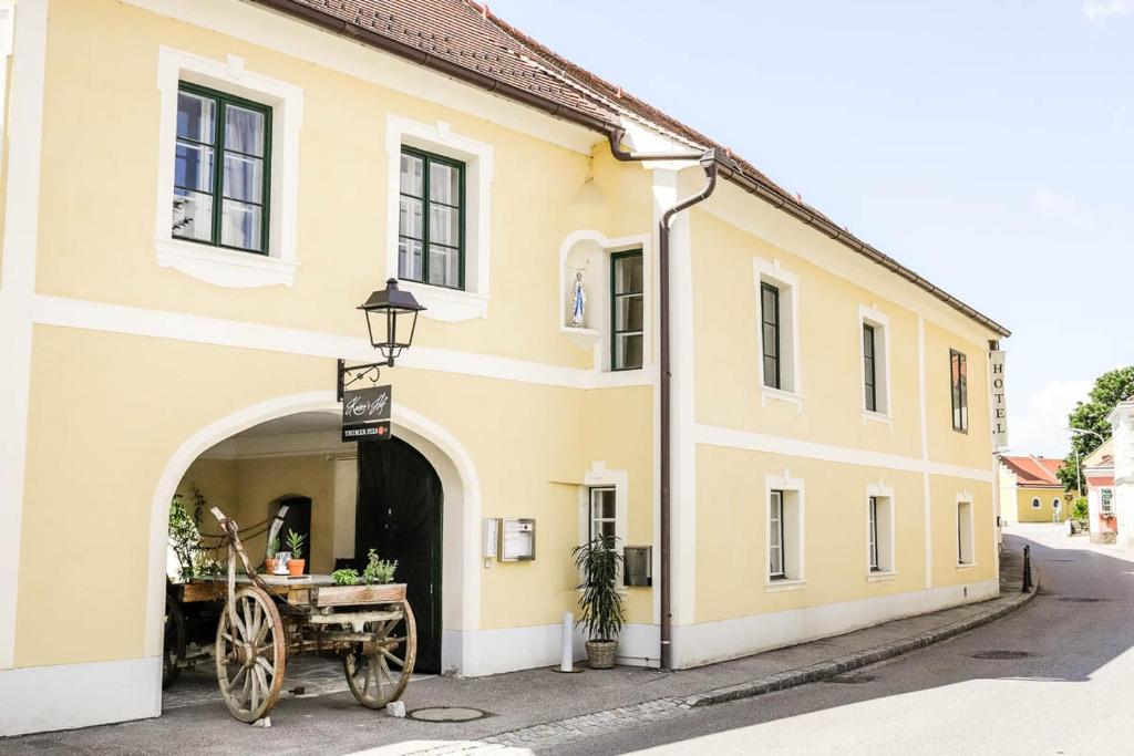 un edificio giallo con una carrozza trainata da cavalli all'esterno di Kaiser's Hof a Strass