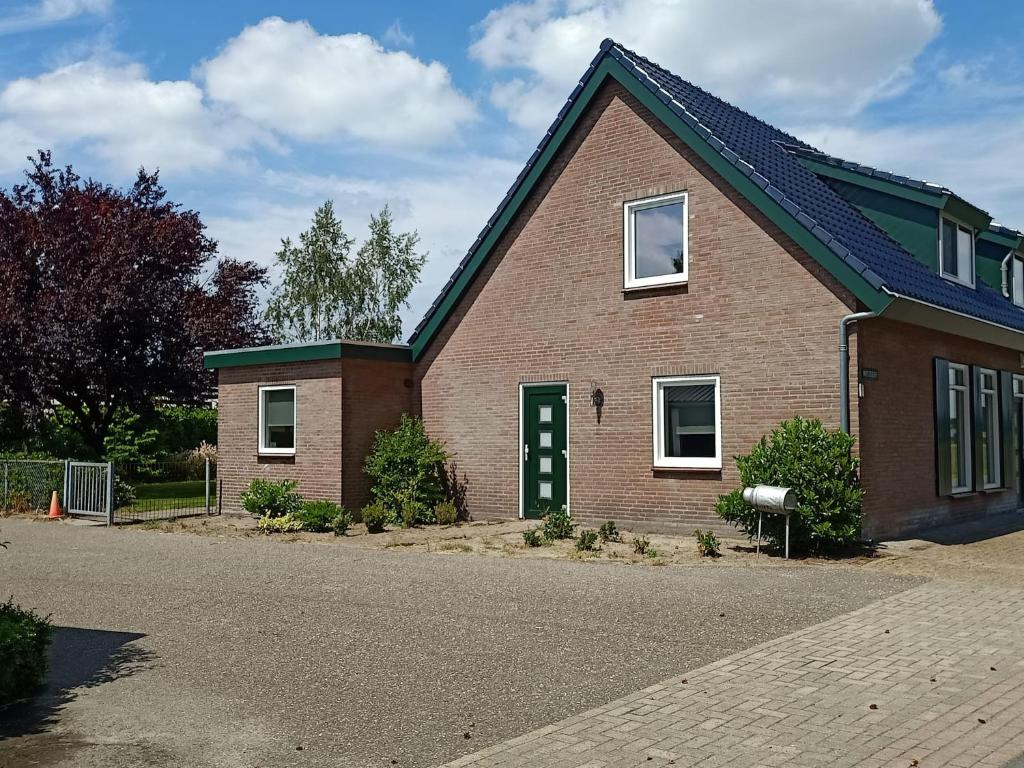 una casa de ladrillo con una puerta verde en una calle en Vakantiehuis Mastdreef, en Breda