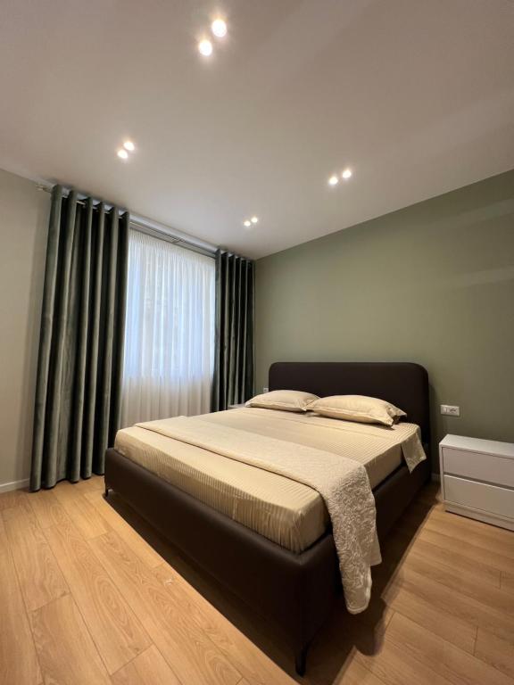 een slaapkamer met een bed en een groot raam bij Costa Adriatica Apartments in Durrës