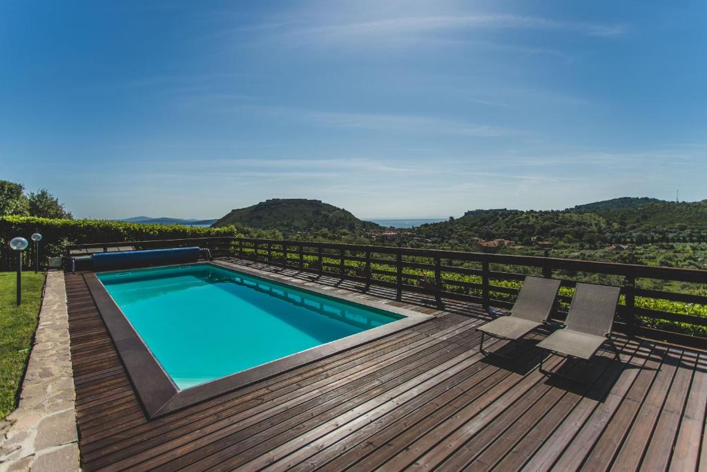 una piscina su una terrazza in legno con 2 sedie di ARGENTARIO Laura's POOL VILLA a Porto Ercole