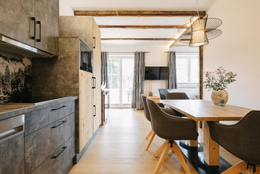 una cucina e una sala da pranzo con tavolo e sedie in legno di SunApart by Apart4you a Haus im Ennstal