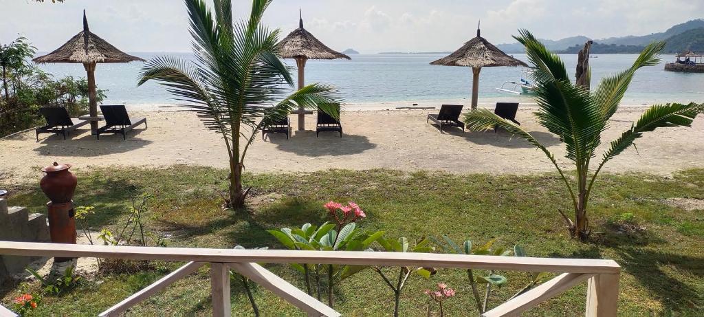 vista su una spiaggia con sedie e ombrelloni di Alam Karang a Gili Gede