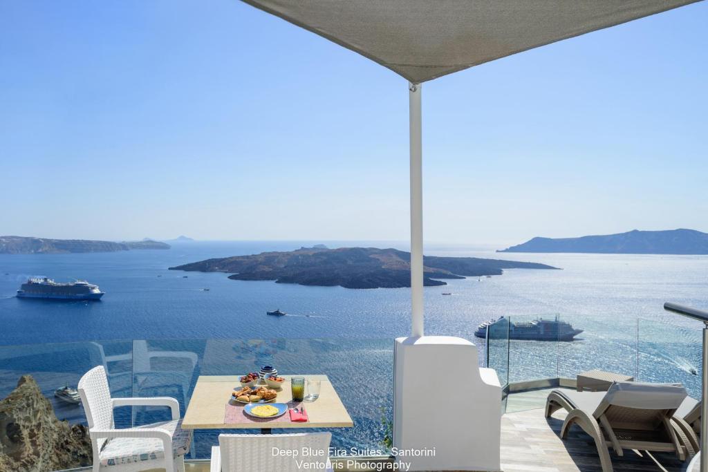 d'une table et de chaises avec vue sur l'océan. dans l'établissement Fira Deep Blue Suites, à Fira