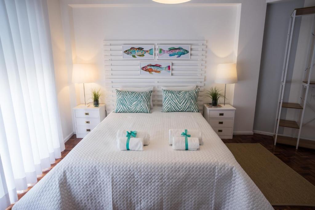 a bedroom with a white bed with two pillows at Casa "Vó Minda" - Nazaré - Alojamento Local in Nazaré