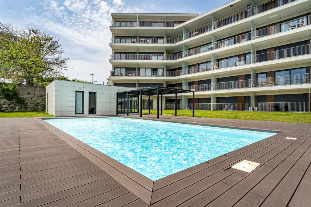 uma grande piscina em frente a um edifício em Antas Park Flat With Pool by YourHost no Porto