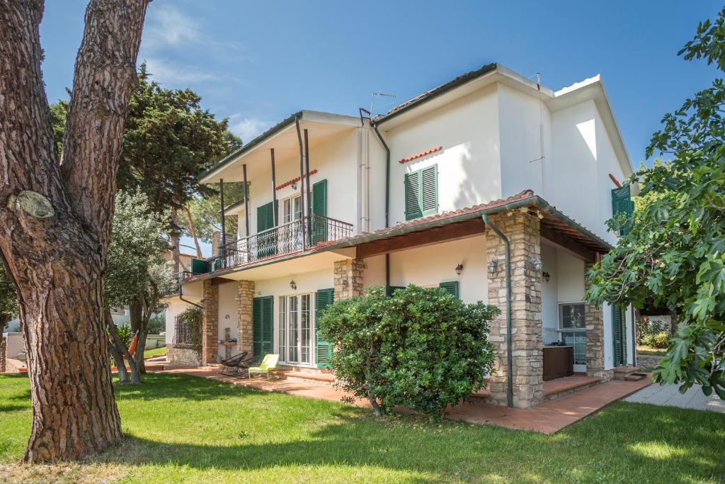 uma vista exterior de uma casa com uma árvore em Piombino Apartments - Villa Pari em Piombino