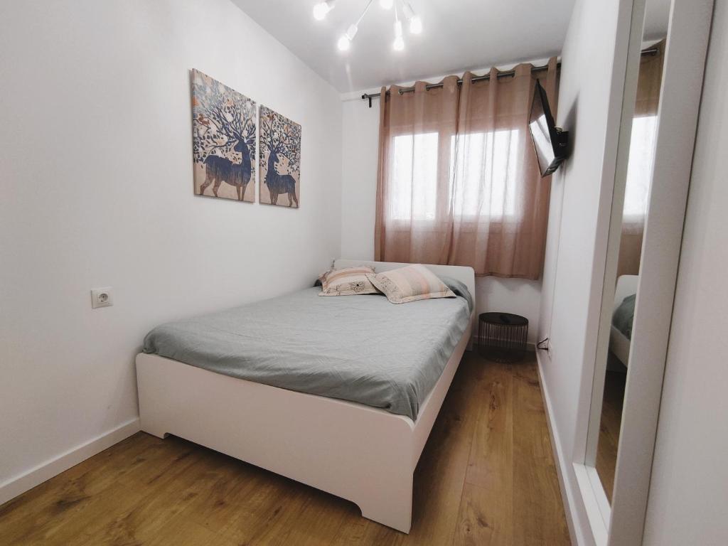 een kleine slaapkamer met een bed en een raam bij Apartamento Santander Maliaño in Maliaño