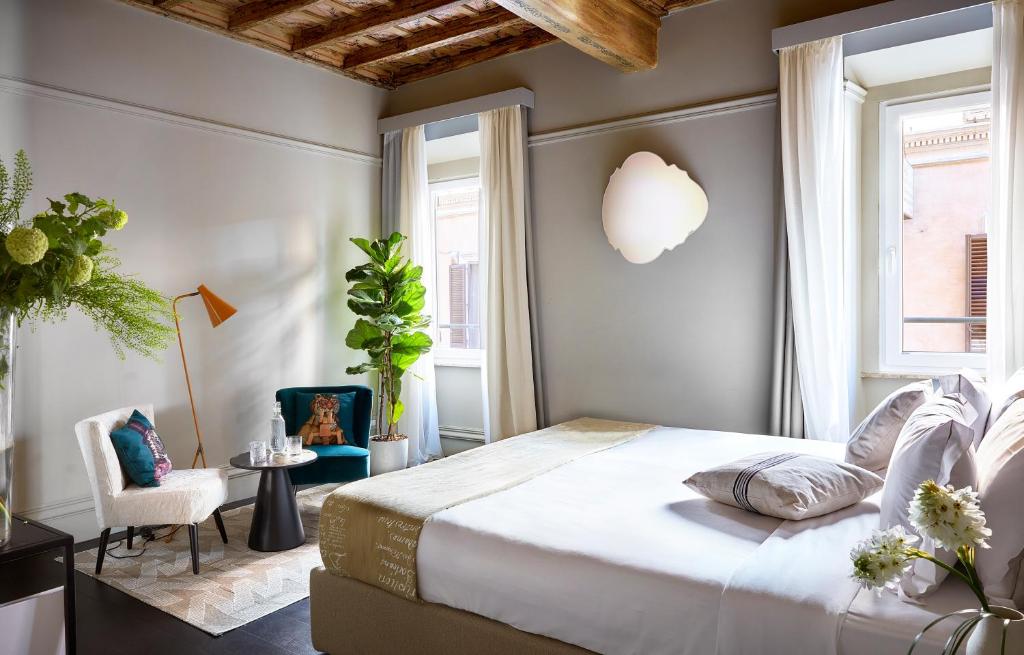 een slaapkamer met een groot bed en een stoel bij HOTEL VITE - By Naman Hotellerie in Rome