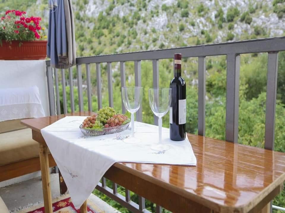 una mesa con dos copas de vino y un tazón de uvas en Apartman Maida, en Blagaj