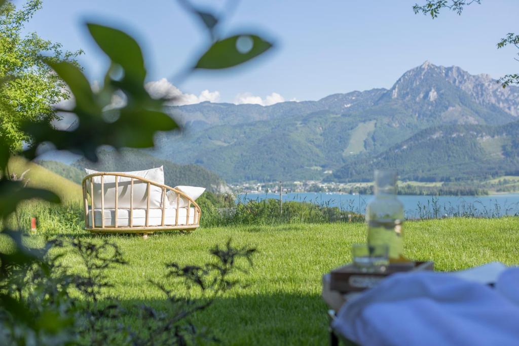 a bed in a field with mountains in the background at Balthasar Volcano Apartments - Adults only in St. Wolfgang