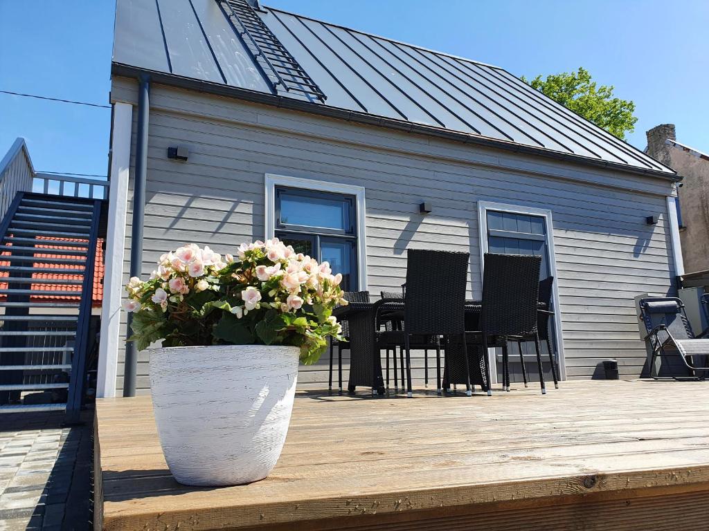 una casa con una maceta de flores en una terraza de madera en KK Apartment, en Ventspils