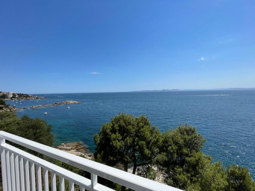 a view of the ocean from a white fence at OverTheSea - PUEBLECITO Apartment in Roses