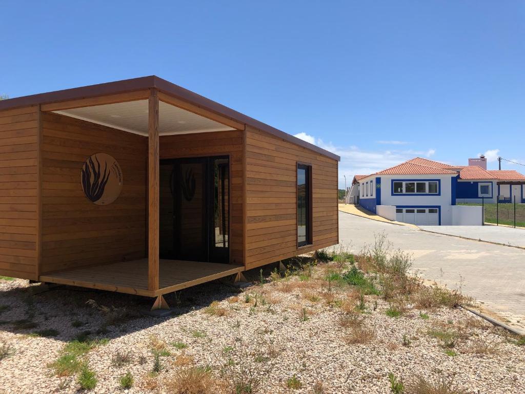 un piccolo edificio con portico sul lato della strada di São Torpes by Campigir a Sines