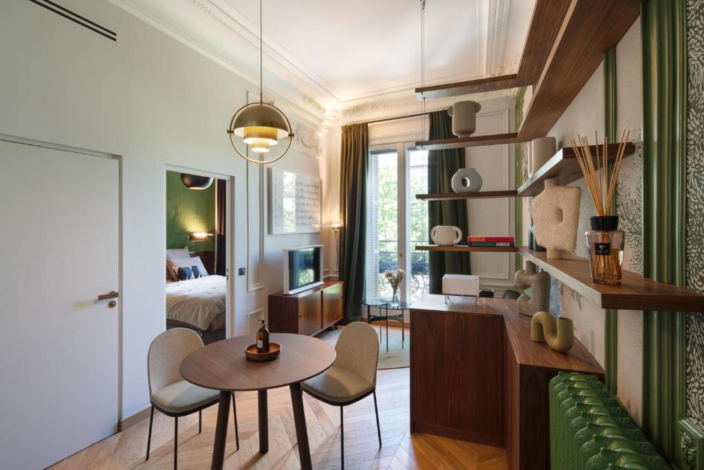 a living room with a table and chairs and a bedroom at Joro Living in Paris