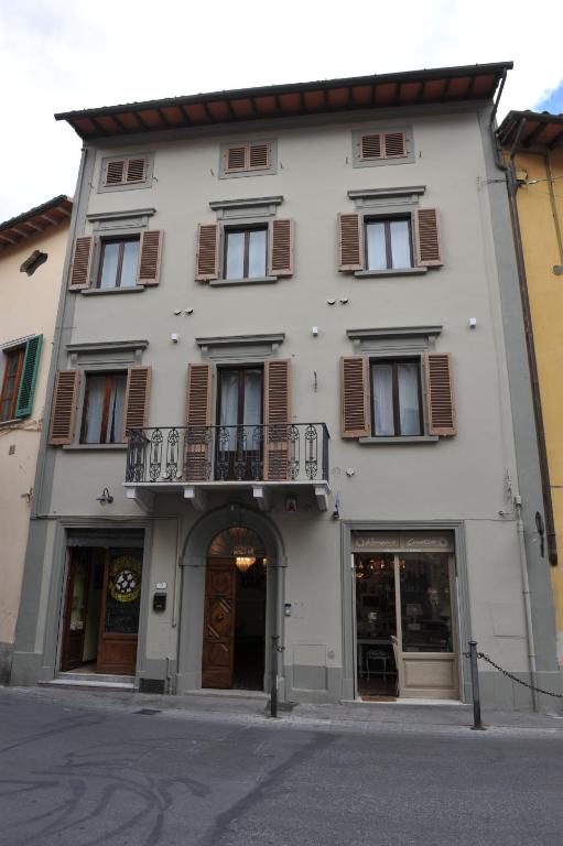 un grande edificio bianco con finestre e balcone di Dimora Sotto la Rocca a San Miniato