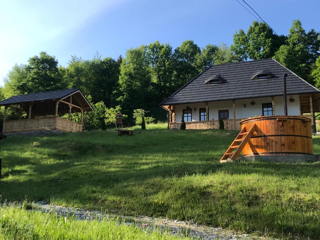 ein Haus mit einem Fass vor einem Hof in der Unterkunft Casa Berg in Vişeu de Sus