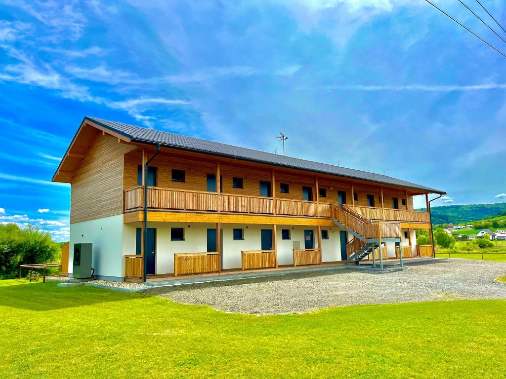 a large wooden building with a green lawn at Sport HOTEL Bečva in Valašské Meziříčí