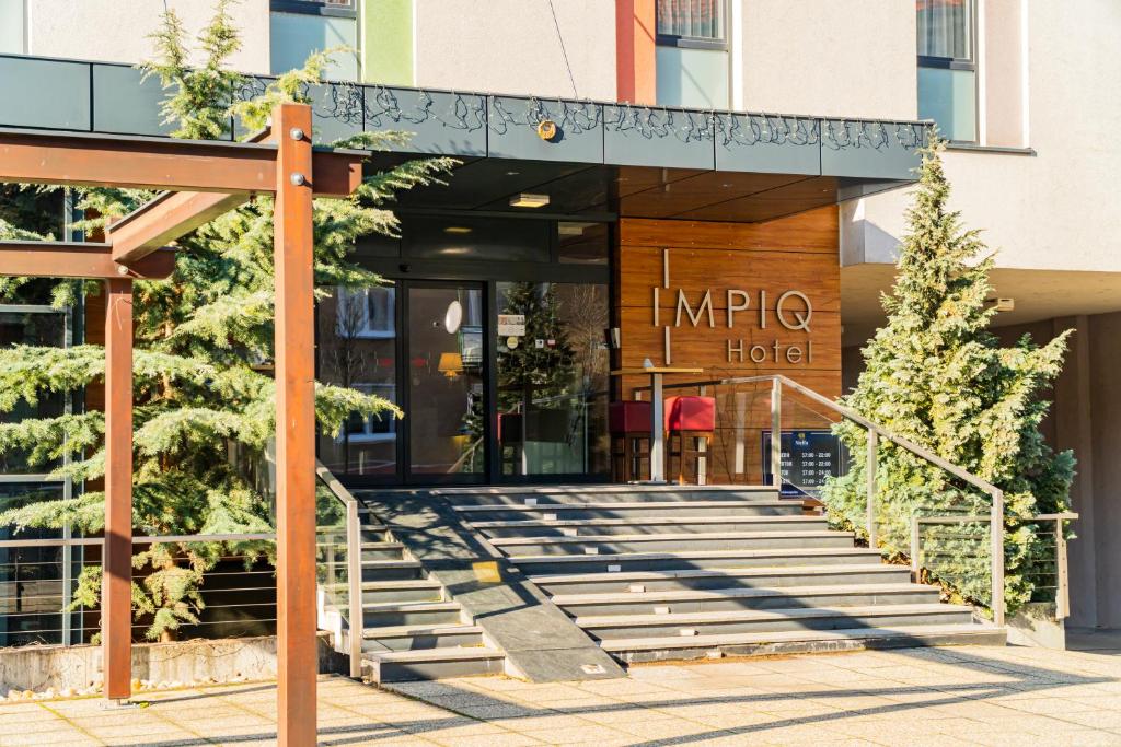 uma entrada do hotel com escadas em frente a um edifício em IMPIQ Hotel em Trnava