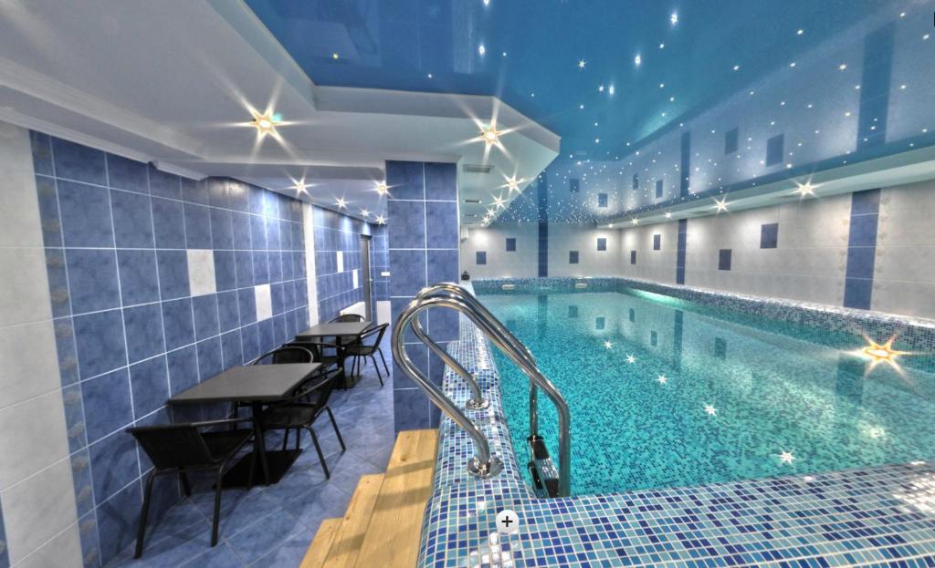 - une piscine dans un hôtel avec des tables et des chaises dans l'établissement Hotel Forward Pool&Sauna, à Yasinya