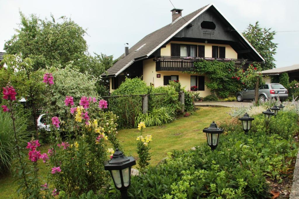 ein Haus mit einem Garten mit Blumen und Lichtern in der Unterkunft Garden Apartments Maria in Bled