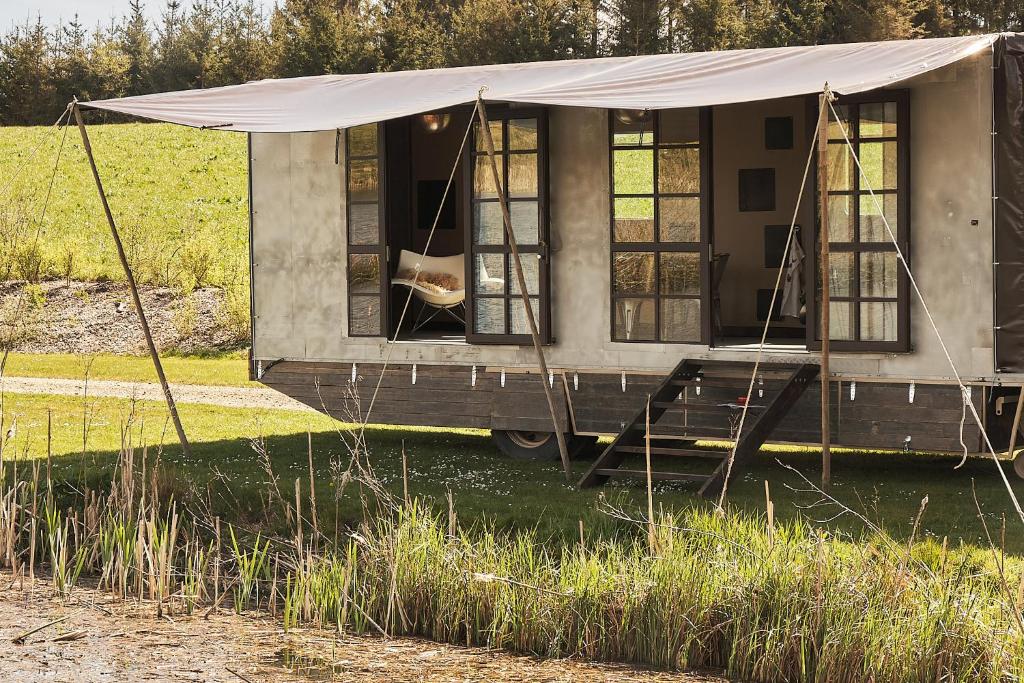 een hond die zijn hoofd uit het raam van een bus steekt bij Krusmølle Glamping in Aabenraa