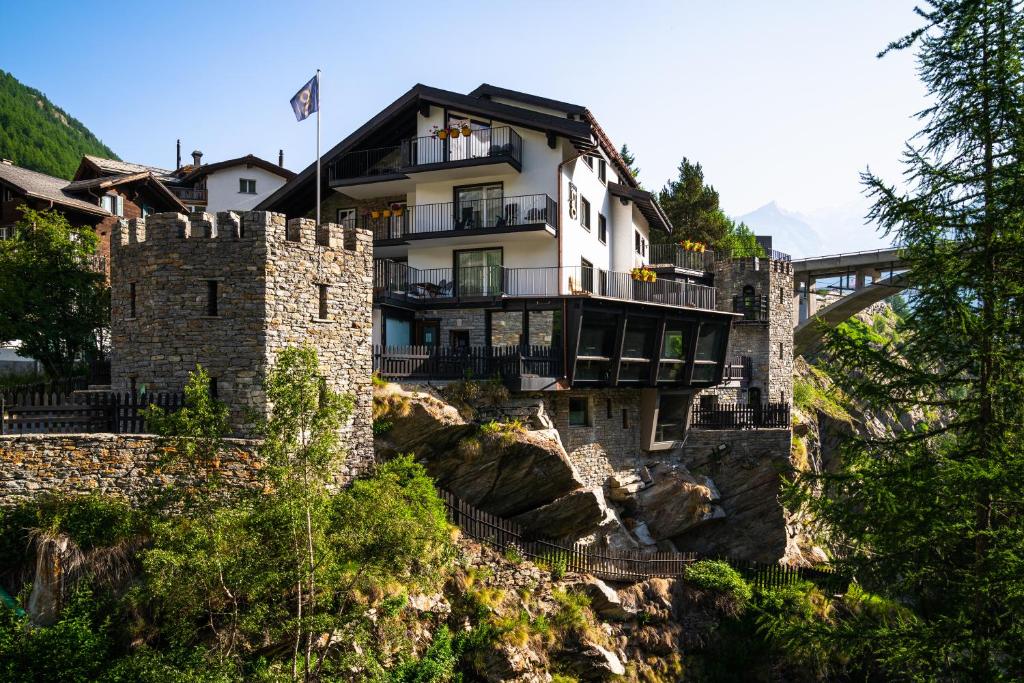 um edifício no topo de uma montanha com uma ponte em Boutique Hotel La Gorge em Saas-Fee