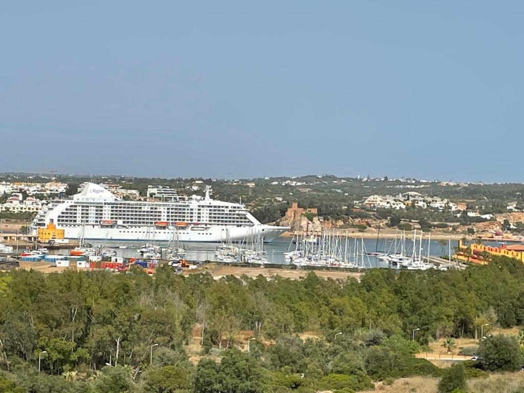 um grande navio de cruzeiro está ancorado num porto em No More Snow, 300 m from the beach, king size bed, fast wi-fi em Portimão