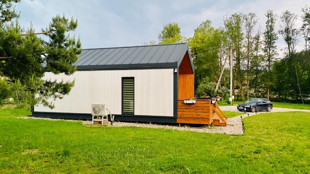 ein kleines Haus mit einem Auto auf einem Hof in der Unterkunft Chill House in Anykščiai