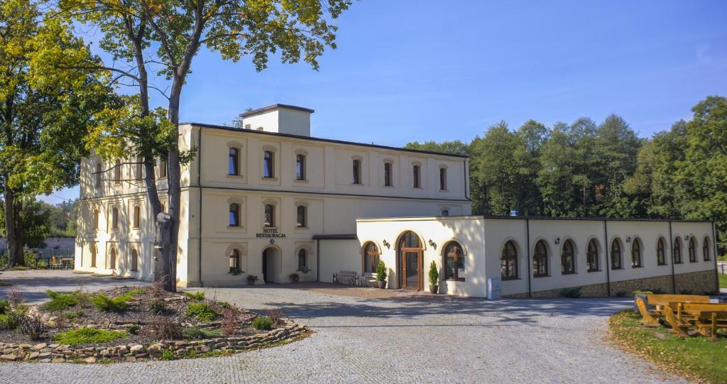 a large white building with a lot of windows at Hotel Stary Młyn in Suchedniów