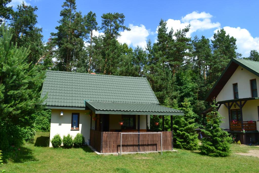 een klein huis met een groen dak bij Domek w Sajenku in Augustów