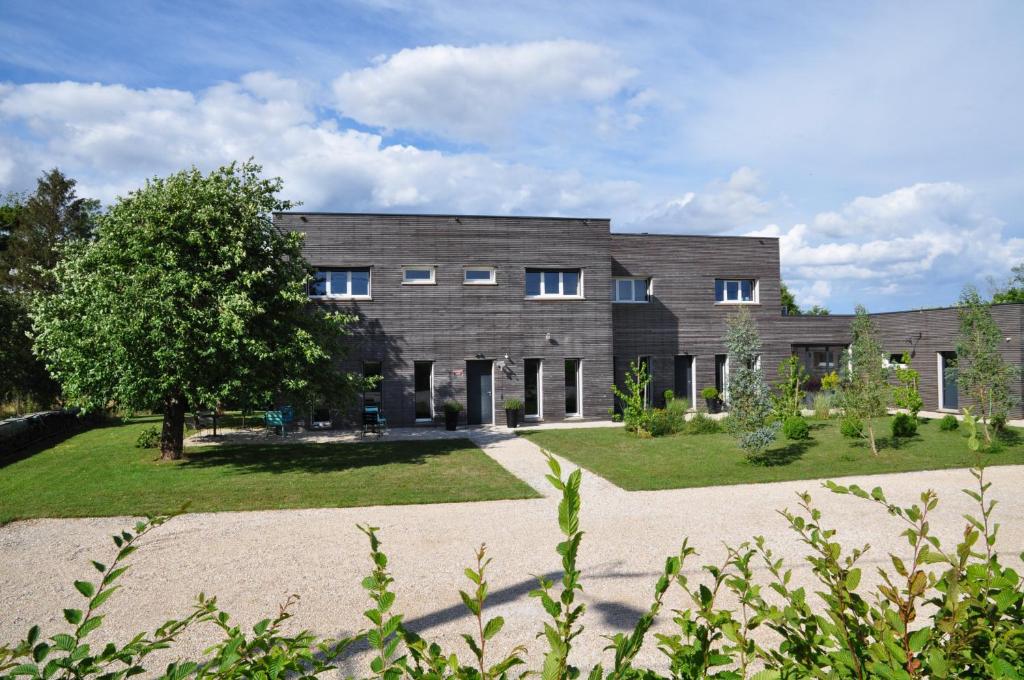 - un grand bâtiment en briques avec un jardin en face dans l'établissement L'Atelier, à Sainte-Marie-du-Lac-Nuisement 