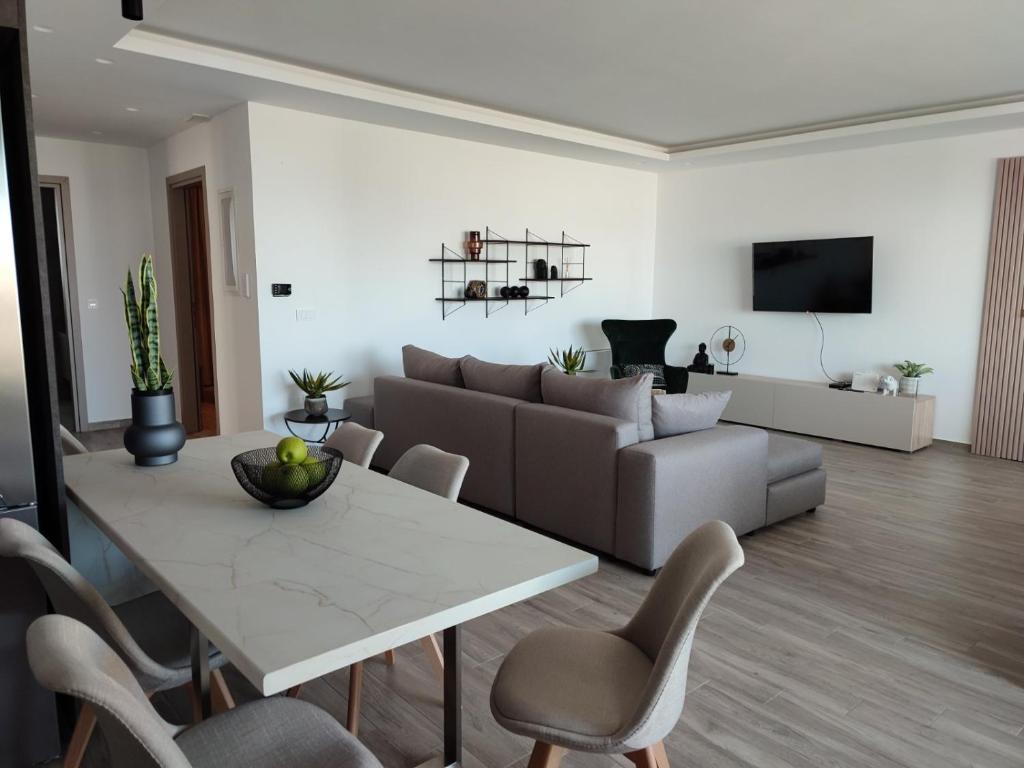 sala de estar con mesa y sofá en VagiaNa apartment Διαμέρισμα κοντά στο αεροδρόμιο, en Antimácheia