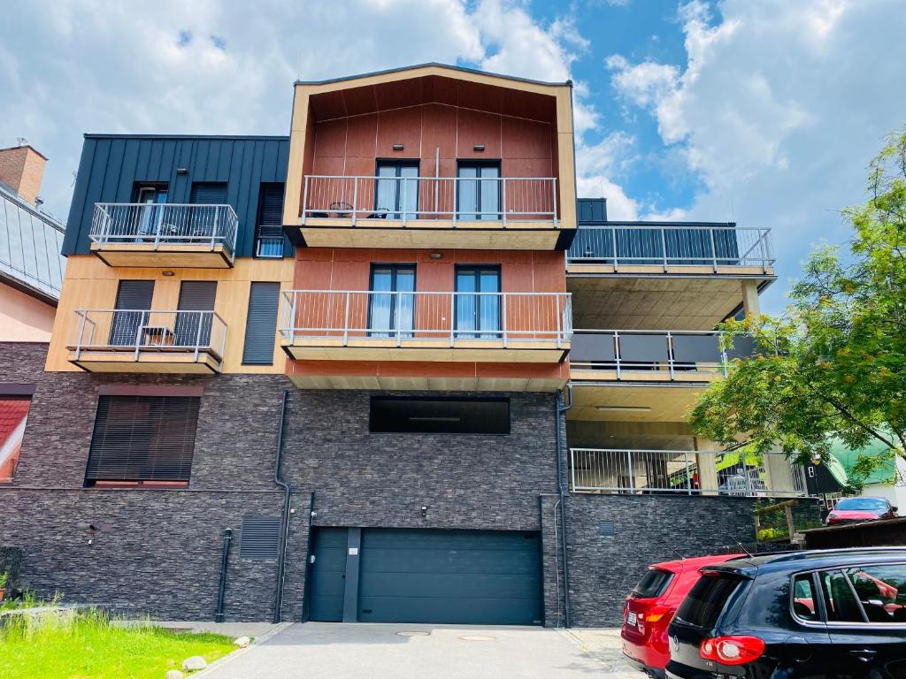 un condominio con garage e una macchina rossa parcheggiata di fronte di Residence Grand - soukromý apartmán a Špindlerův Mlýn