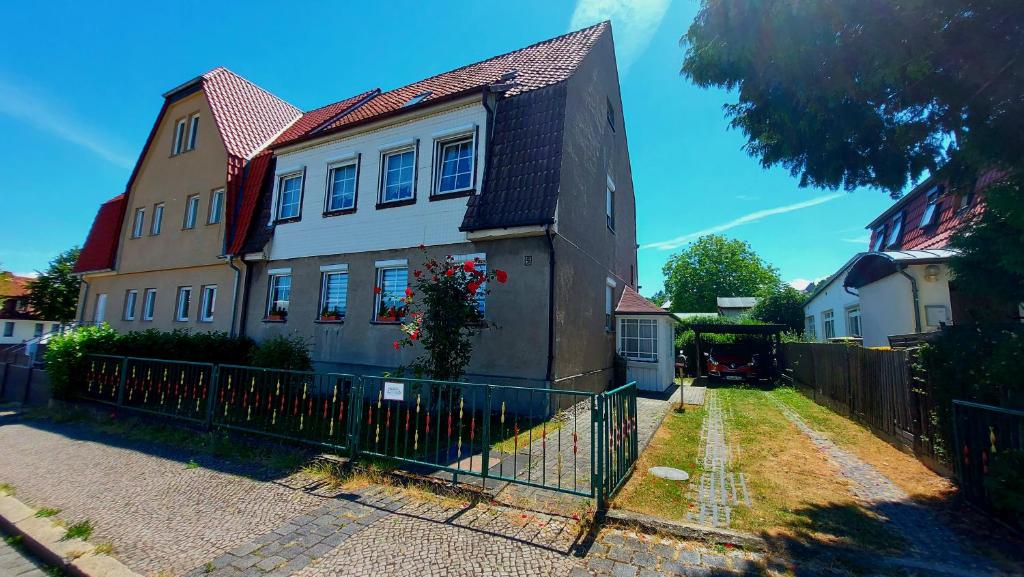 a house with a fence in front of it at Rummy's Ferienwohnung mit Garten in Wernigerode