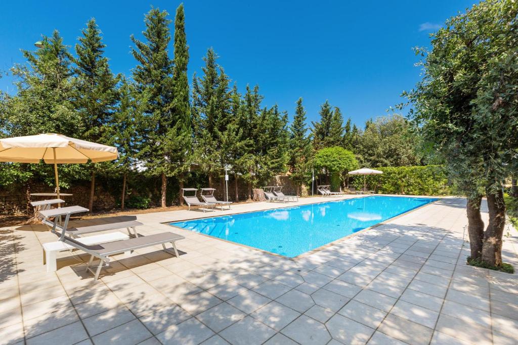 - une piscine avec 2 chaises et un parasol dans l'établissement B&B Luxury da Salvatore, à Presicce