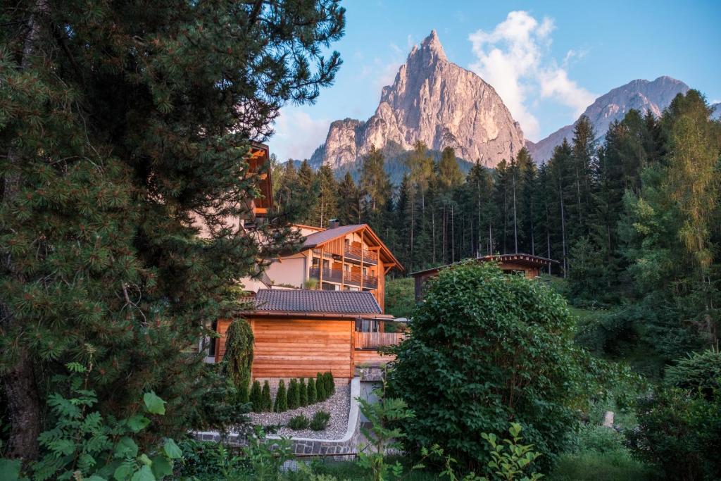 domek z bali z górą w tle w obiekcie Hotel Waldrast Dolomites w mieście Siusi