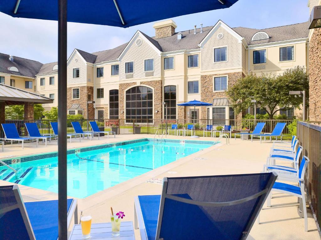 una piscina con sedie blu e un edificio di Sonesta ES Suites Houston Galleria a Houston