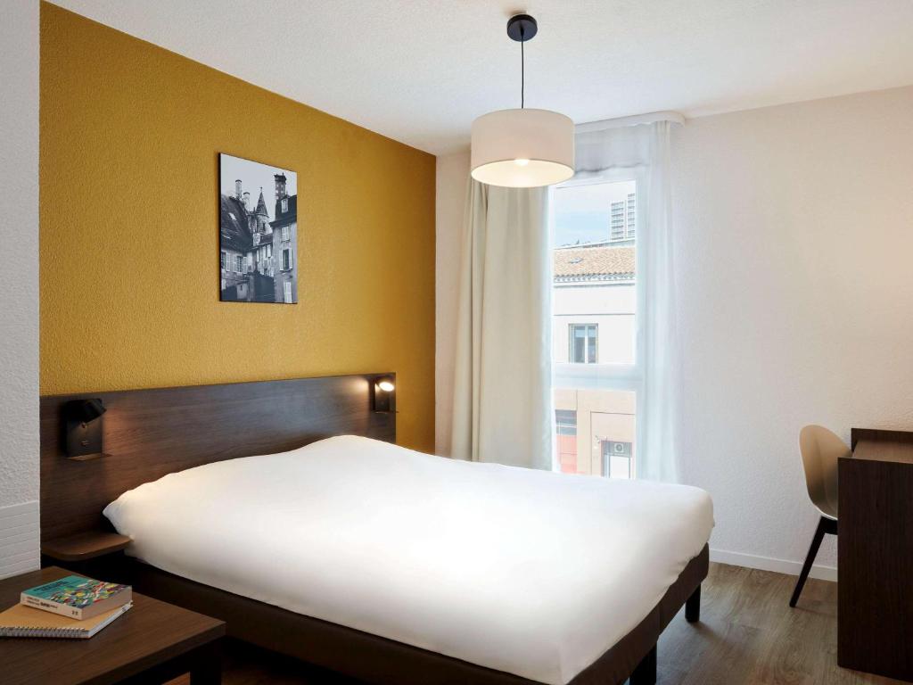 Cama ou camas em um quarto em Aparthotel Adagio Access Poitiers