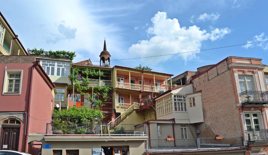 een groep gebouwen met een kerktoren op de achtergrond bij Apartment Paysage in Tbilisi City