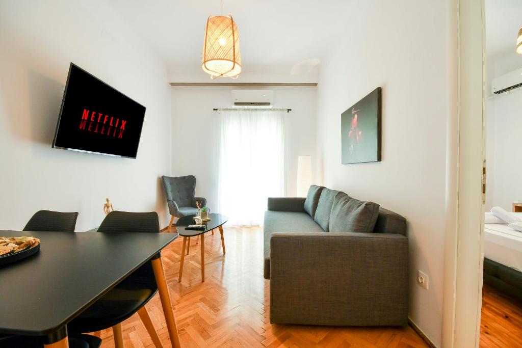 Thessaloniki Center Comfortable Apartment في سلانيك: غرفة معيشة مع أريكة وطاولة