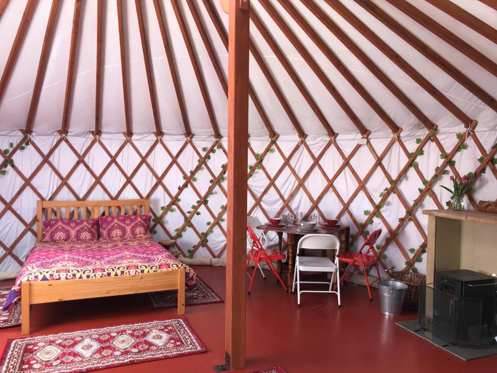 En eller flere senge i et værelse på The Yurts at Burnt House Farm