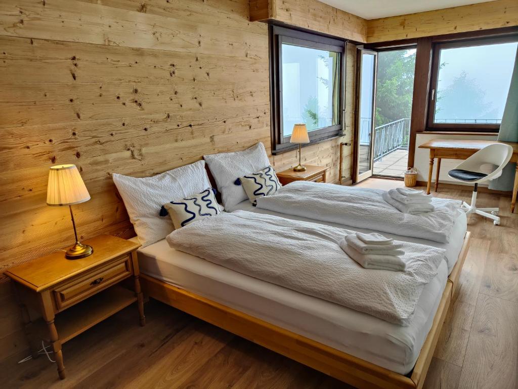 1 dormitorio con 1 cama y pared de madera en Hotel Bergsonne Rigi, en Rigi Kaltbad