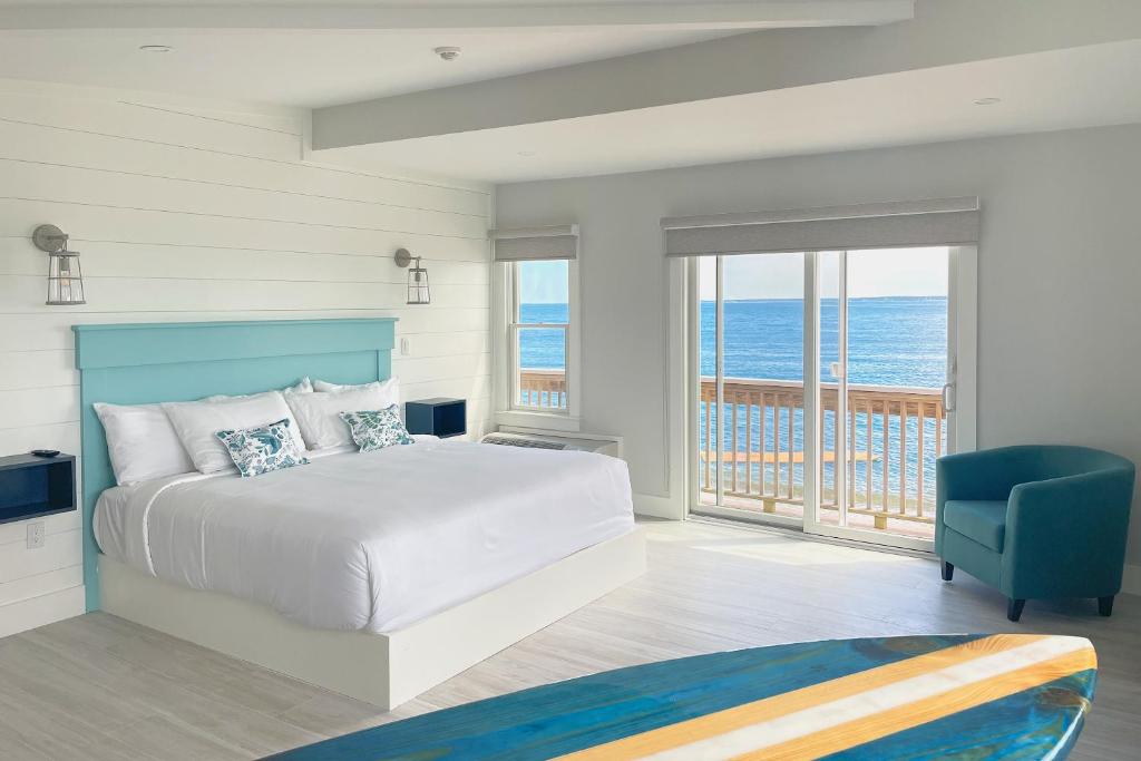 a bedroom with a bed and a view of the ocean at Falmouth Tides in Falmouth