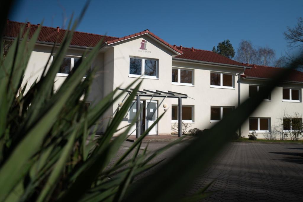 un bâtiment blanc avec un toit rouge dans l'établissement Haus Hotel Inter, à Buxtehude