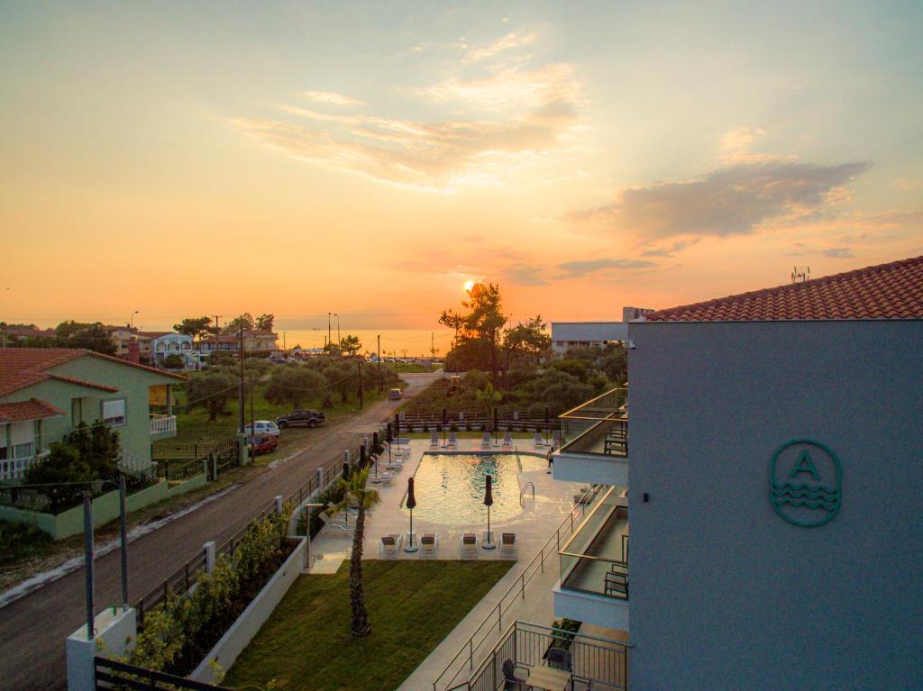 vista para uma piscina a partir de um edifício ao pôr-do-sol em The Angeliki Boutique Hotel em Skala Rachoniou