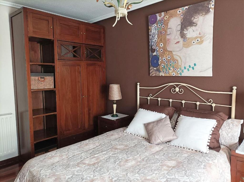 a bedroom with a bed and a painting on the wall at Apartamento El Rincón de Pilar in El Astillero