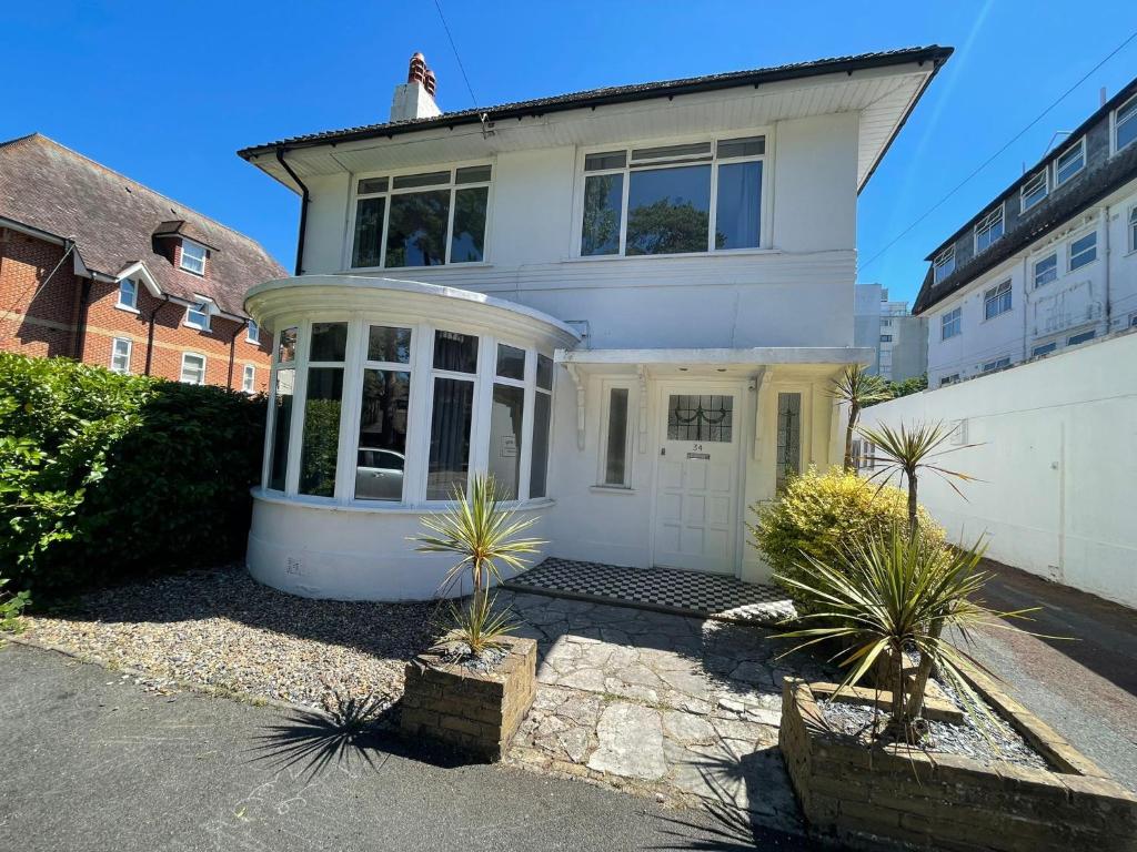 a white house with plants in front of it at Bayside GuestHouse in Bournemouth