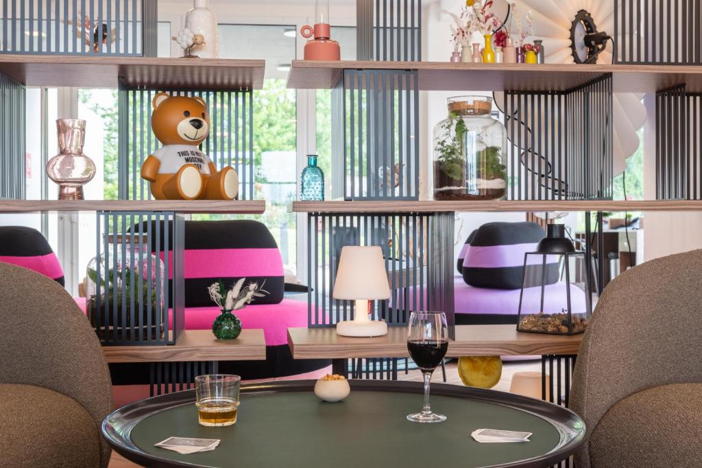 ein Zimmer mit einem Tisch und einem Teddybär auf einem Regal in der Unterkunft Hôtel Omnubo Collection in Les Épesses