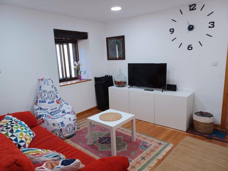 a living room with a couch and a clock on the wall at Bonito apartamento en Laredo in Laredo